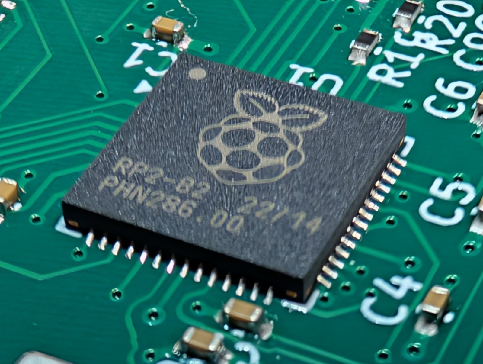 RP2040のQFNパッケージの拡大写真。周囲に0402のコンデンサが並ぶ